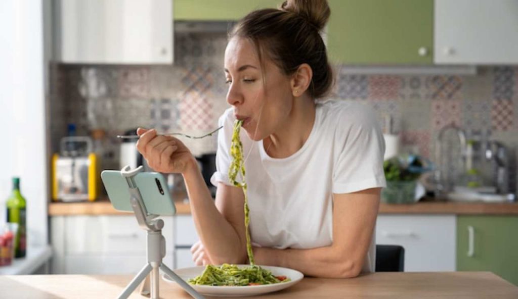 Donna che mangia pasta con il pesto