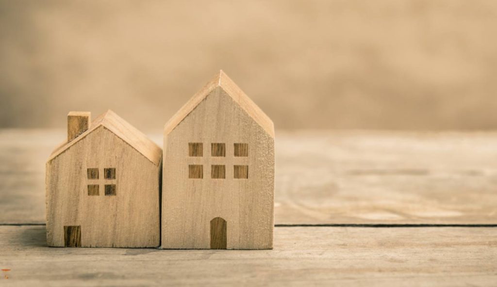 Illustrazione di due case in legno (Canva FOTO) - buildingcue.it