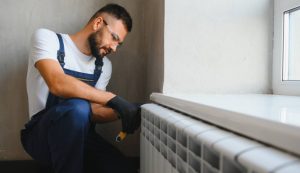 Illustrazione della manutenzione di un termosifone (Canva FOTO) - buildingcue.it